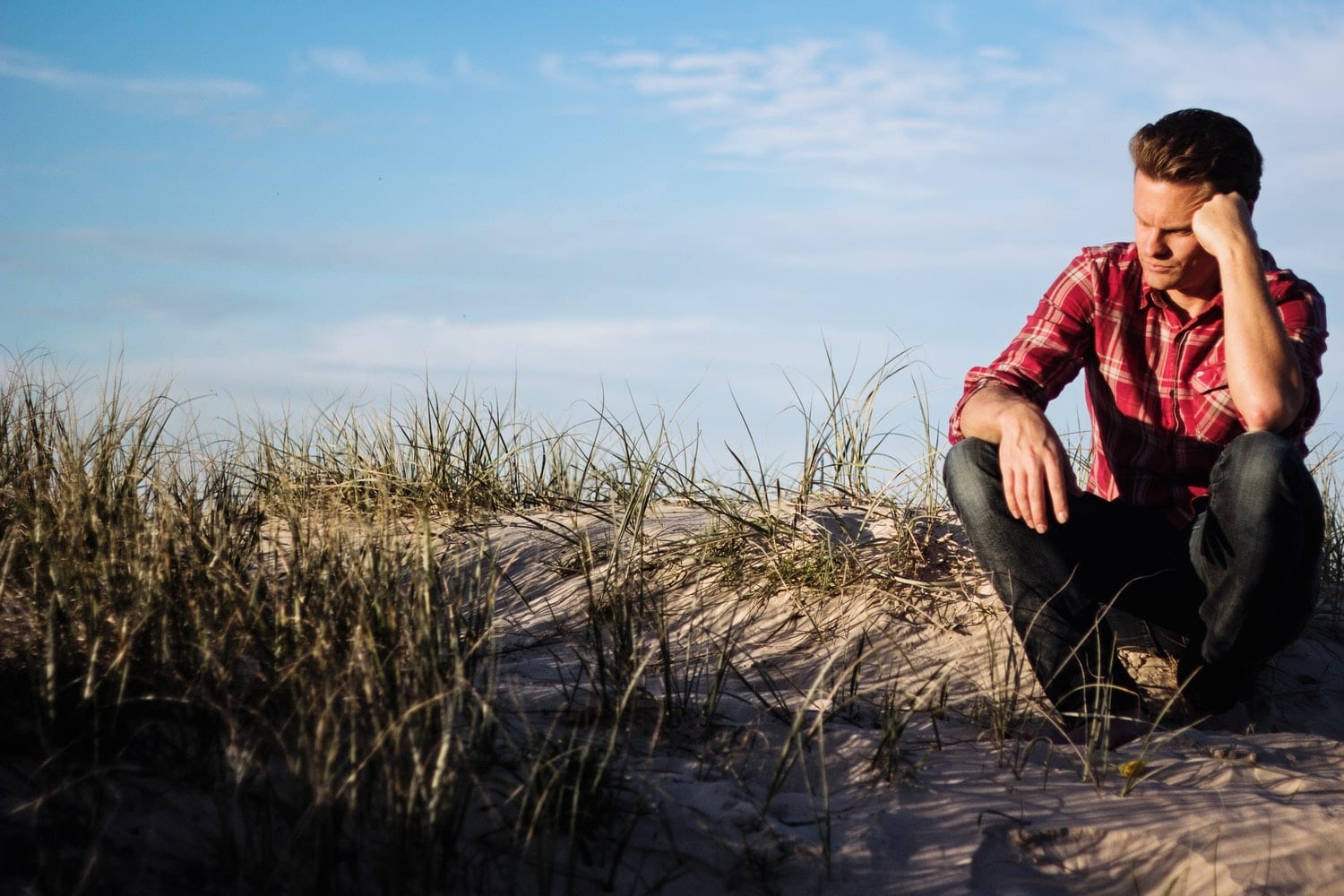 Man in red shirt thinking